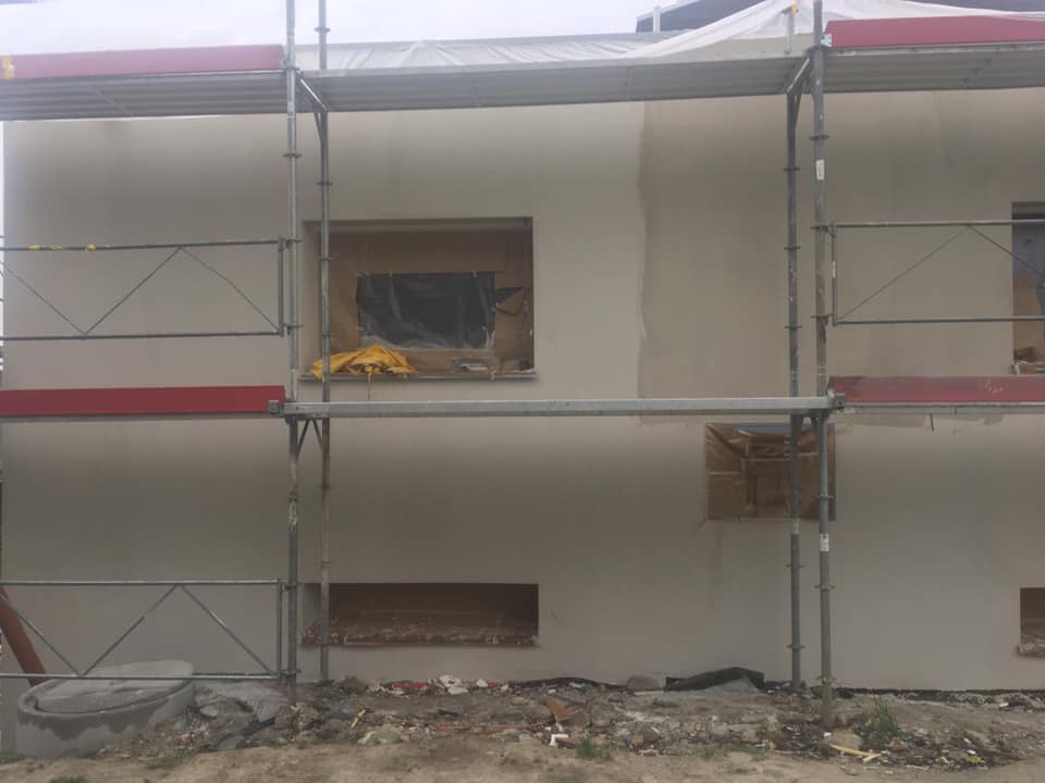 Façade de bâtiment en construction avec échafaudages.