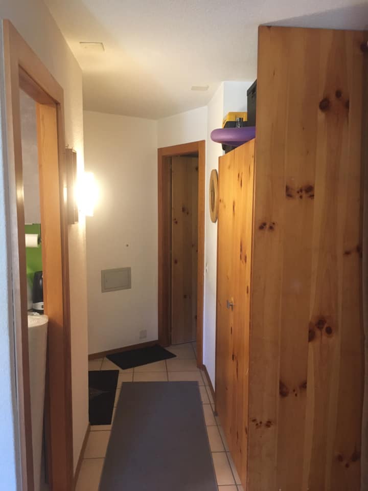 Couloir avec portes en bois, éclairage mural.