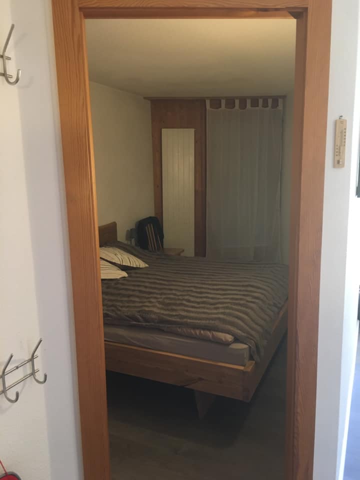 Chambre avec lit double en bois.