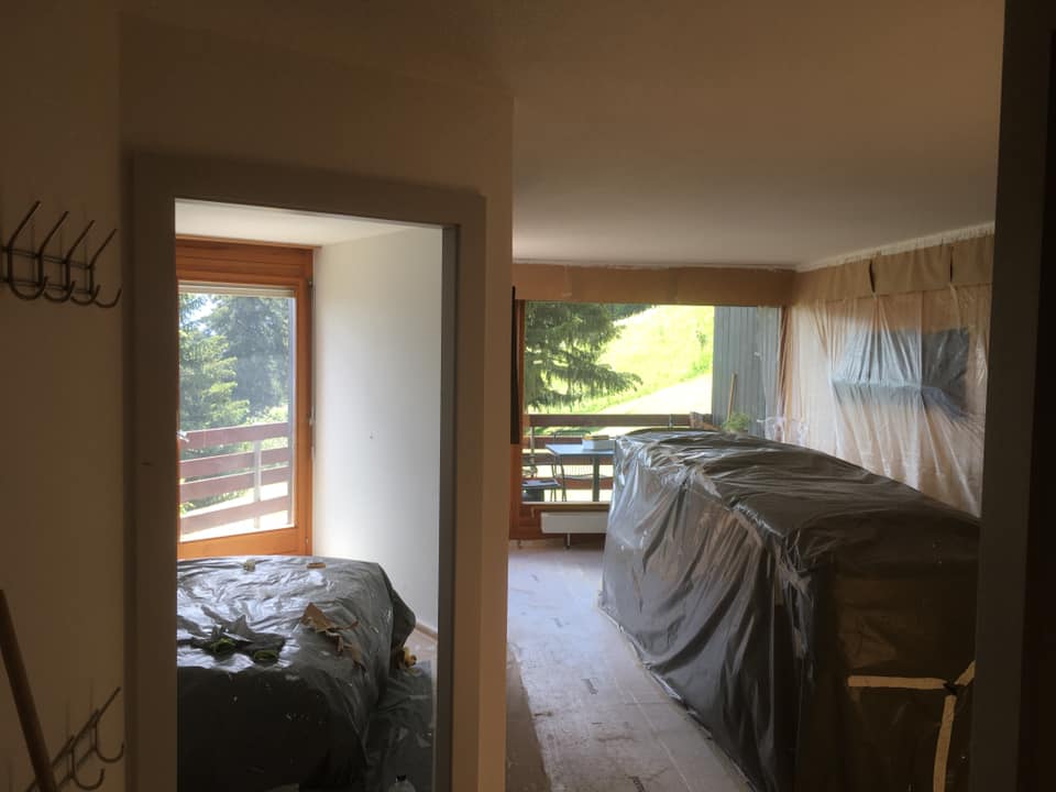 Chambre en rénovation avec vue sur balcon.