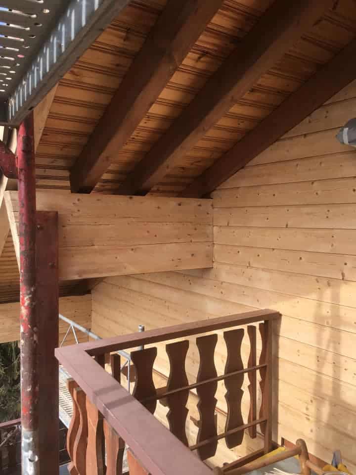Balcon en bois avec toit incliné.