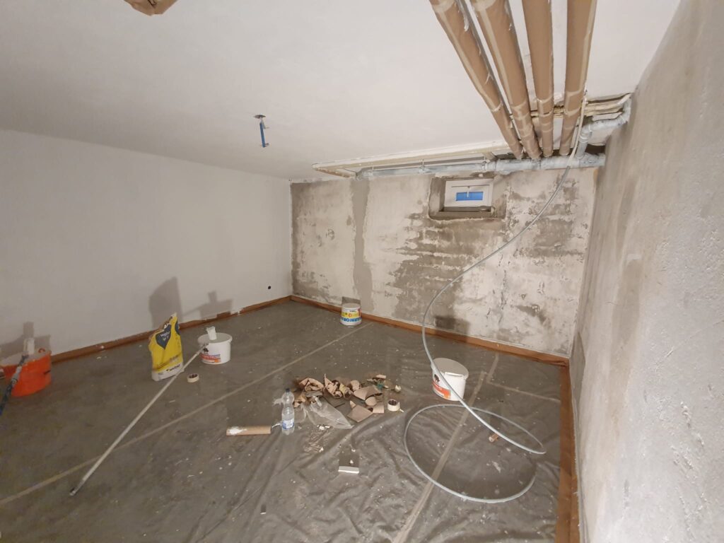 Sous-sol en rénovation avec matériel de peinture.
