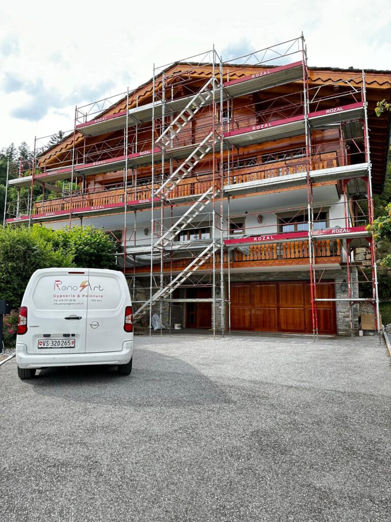 Maison avec échafaudage, véhicule d'artisan devant.