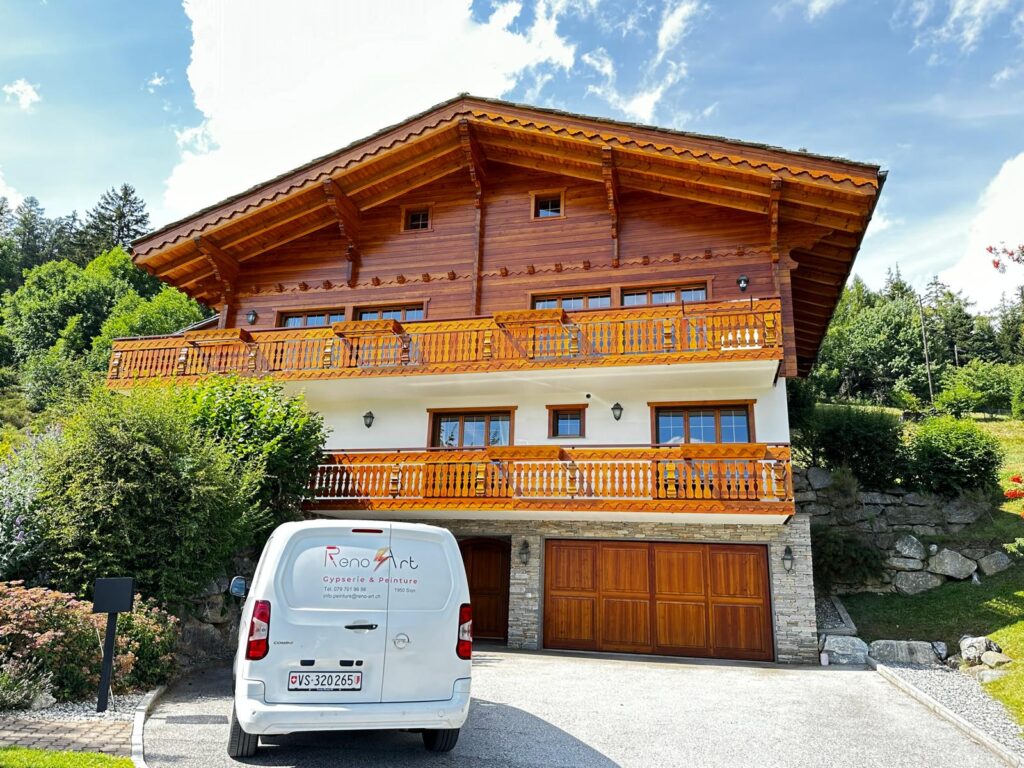 Chalet en bois avec fourgonnette blanche devant.